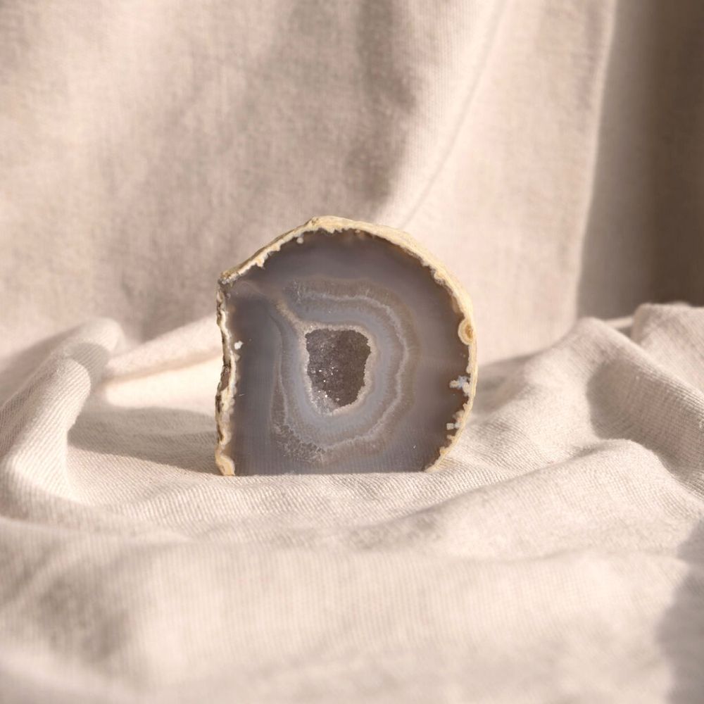 Prachtige Agaat edelsteeen in het grijsblauw met in het midden een opening met hele kleine bergkristallen