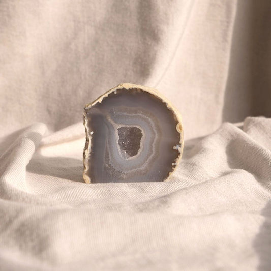 Prachtige Agaat edelsteeen in het grijsblauw met in het midden een opening met hele kleine bergkristallen