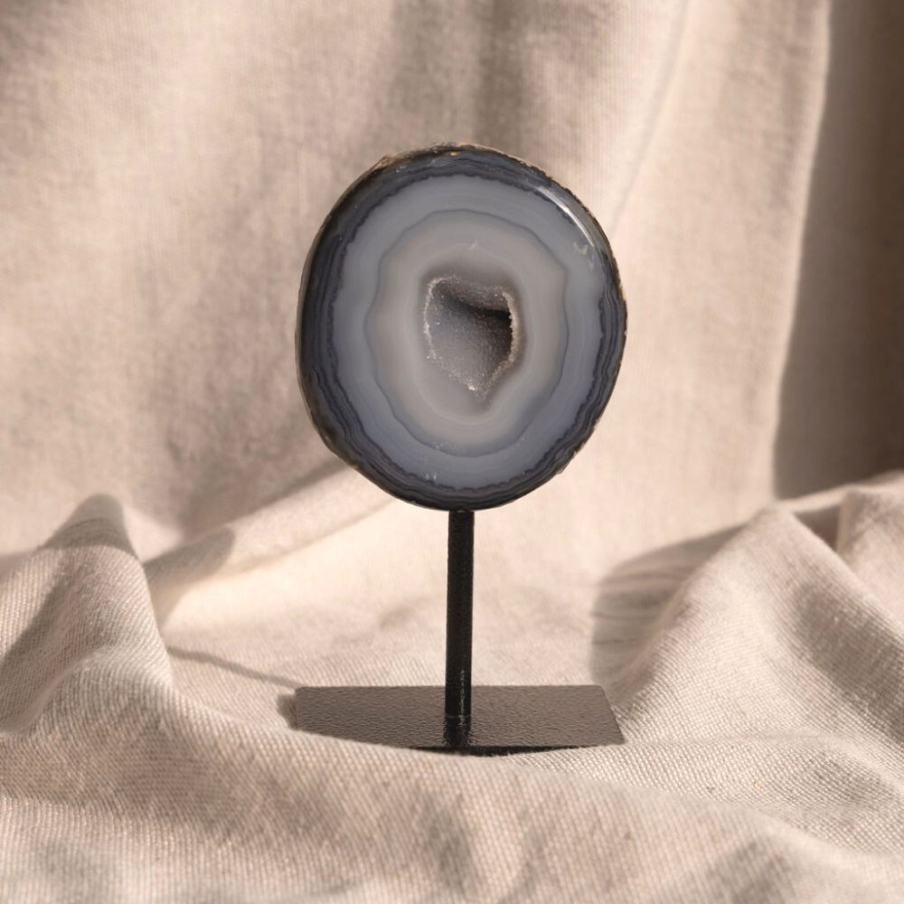 Agaat op standaard in het grijsblauw met in het midden een opening met kleine bergkristallen