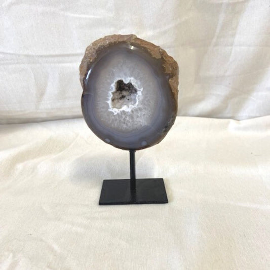Halve Agaat Geode op standaard met een mooie agaattekening en in de opening schitterende kleine bergkristallen