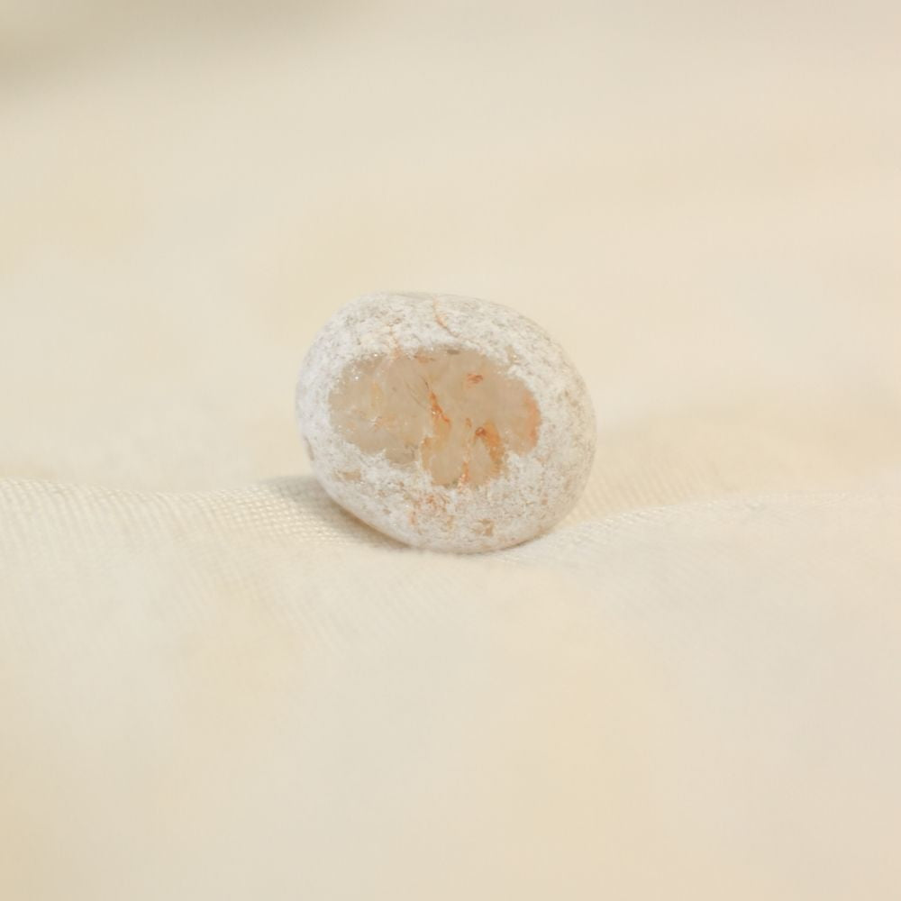 Rookkwarts Ema Egg met aan de ene kant een gepolijste zijde en aan de andere kant een ruwe zijde. Deze ruwe zijde lijkt ent gedoopt te zijn in poedersuiker en heeft een ronde of  ovalen vorm
